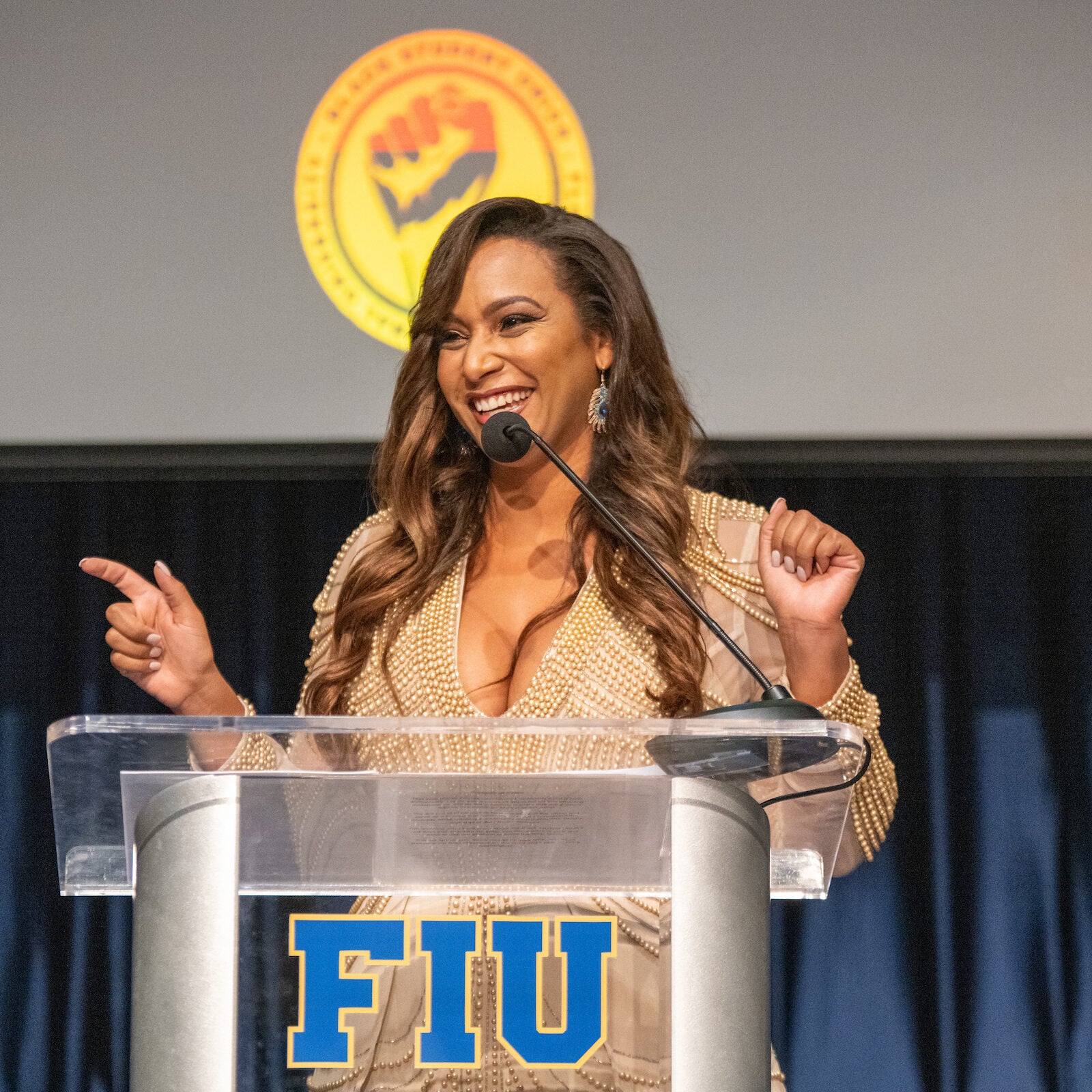 Tamika speaking on stage behind a podium