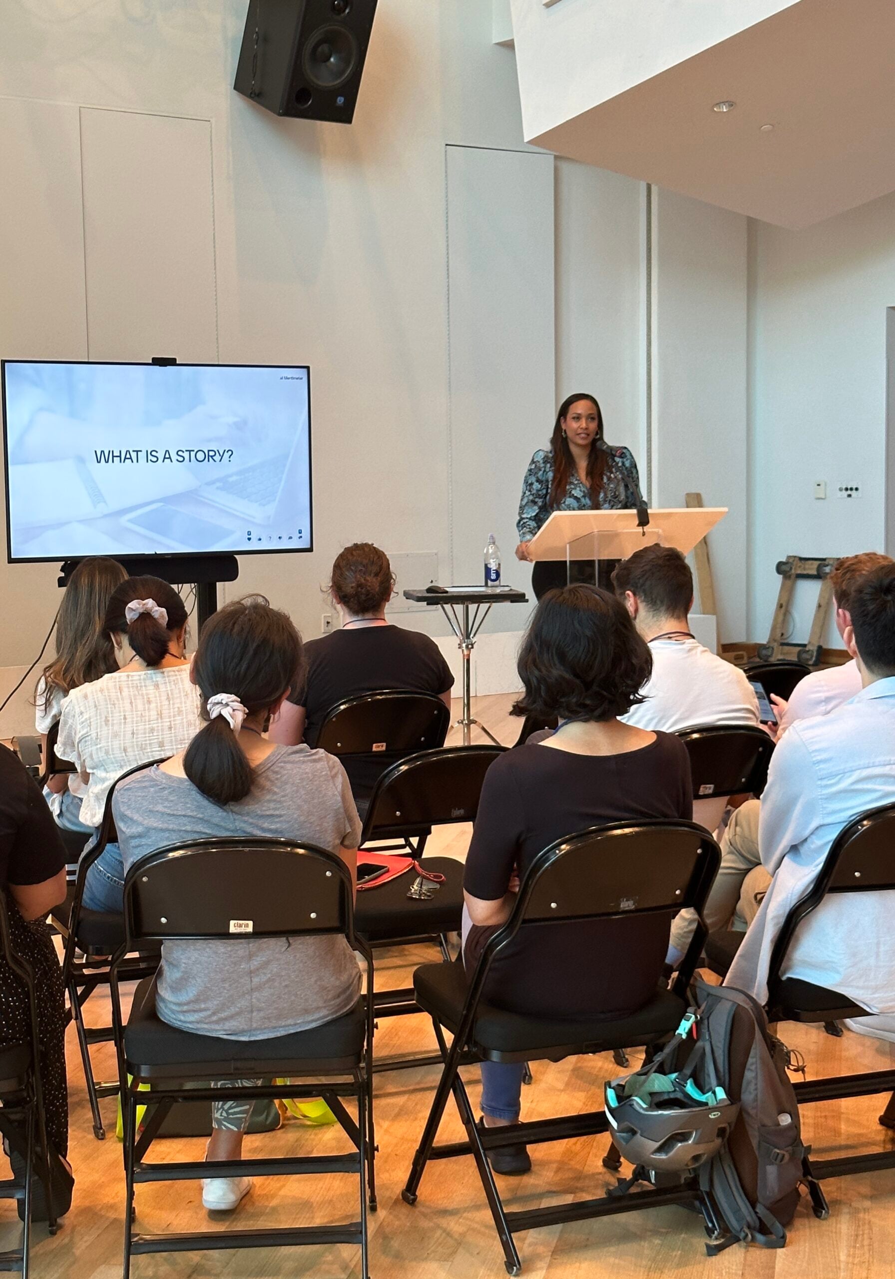 Tamika speaking in front of a seated group